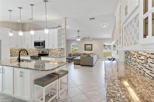 a large white kitchen with a sink and a large window