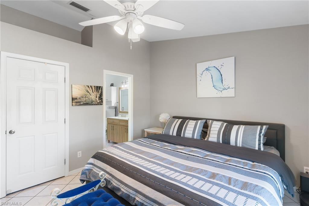 1061 15th Street Southwest Naples, FL 34117 - Photo 15 of 47 a bedroom with a large bed and a chandelier