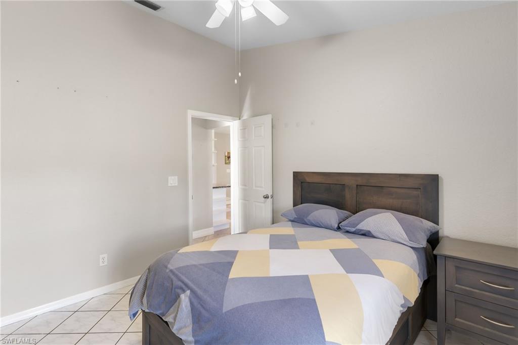 1061 15th Street Southwest Naples, FL 34117 - Photo 17 of 47 a bedroom with a bed and a chandelier