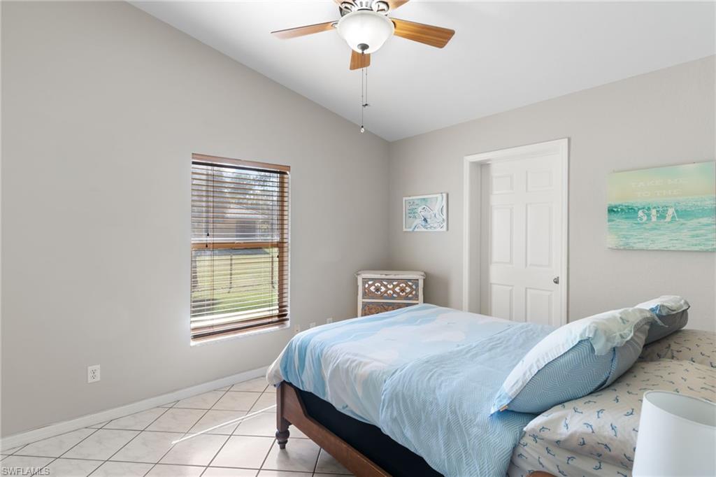 1061 15th Street Southwest Naples, FL 34117 - Photo 18 of 47 a bedroom with a large bed and a chandelier