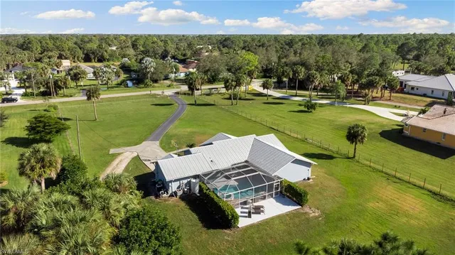 an aerial view of a house with a garden and lake view