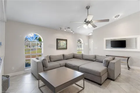 a living room with furniture a chandelier and a window