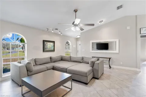 a living room with furniture a ceiling fan and a window