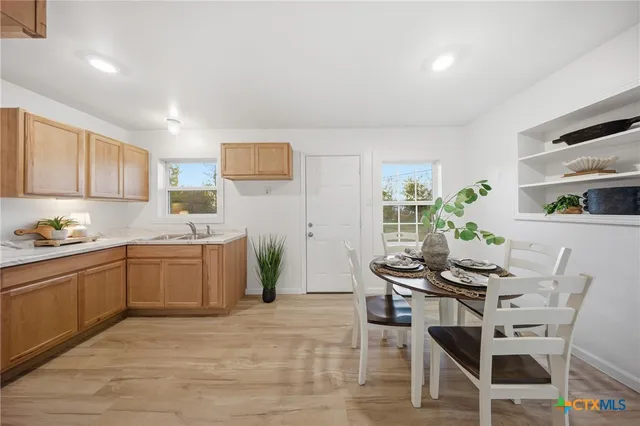 a kitchen with a dining table chairs and white appliances