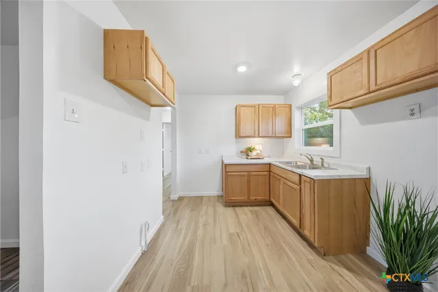 a view of a kitchen with fridge and wooden floor