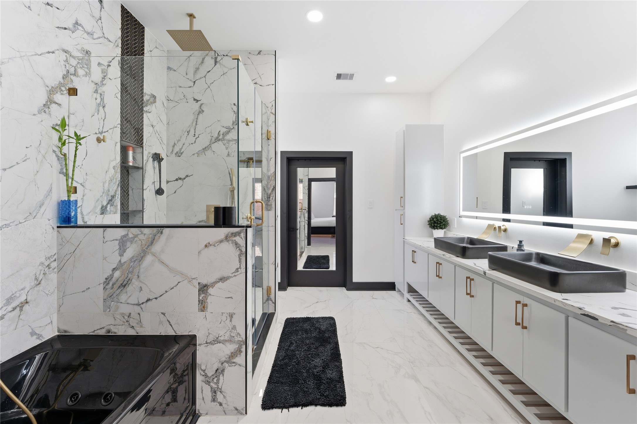7737 Edna Street Houston, TX 77087 - Photo 13 of 43 a bathroom with a double vanity sink a large mirror and a shower