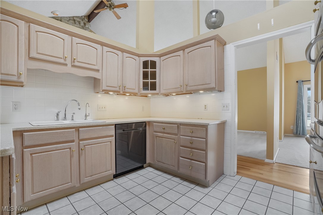 1094 San Raphael Drive Akron, OH 44333 - Photo 20 of 50 Kitchen featuring light brown cabinetry, dishwasher, decorative backsplash, glass insert cabinets, and a ceiling fan