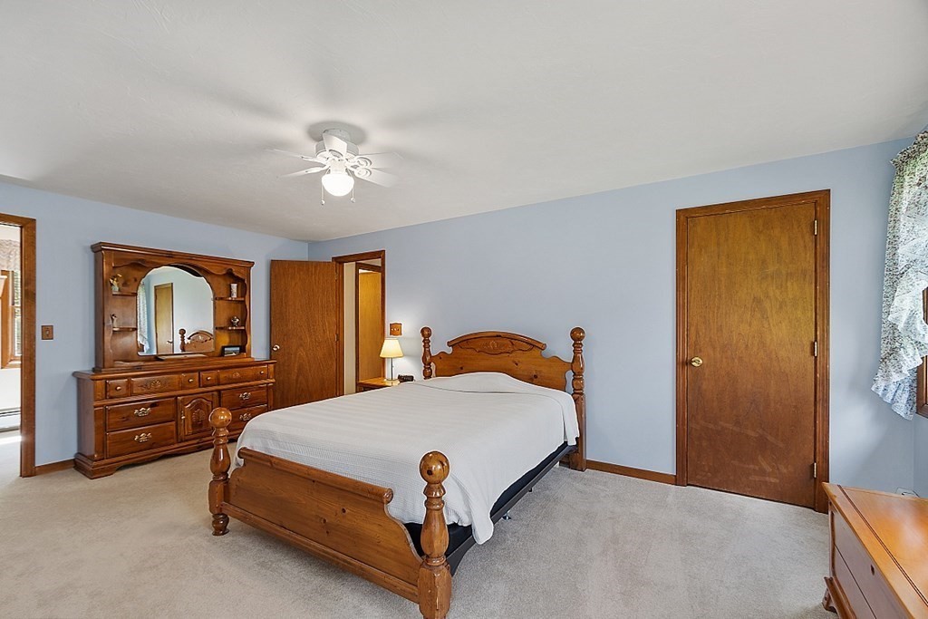 20 Rhodes Road Princeton, MA 01541 - Photo 18 of 35 a bedroom with a bed and a chandelier