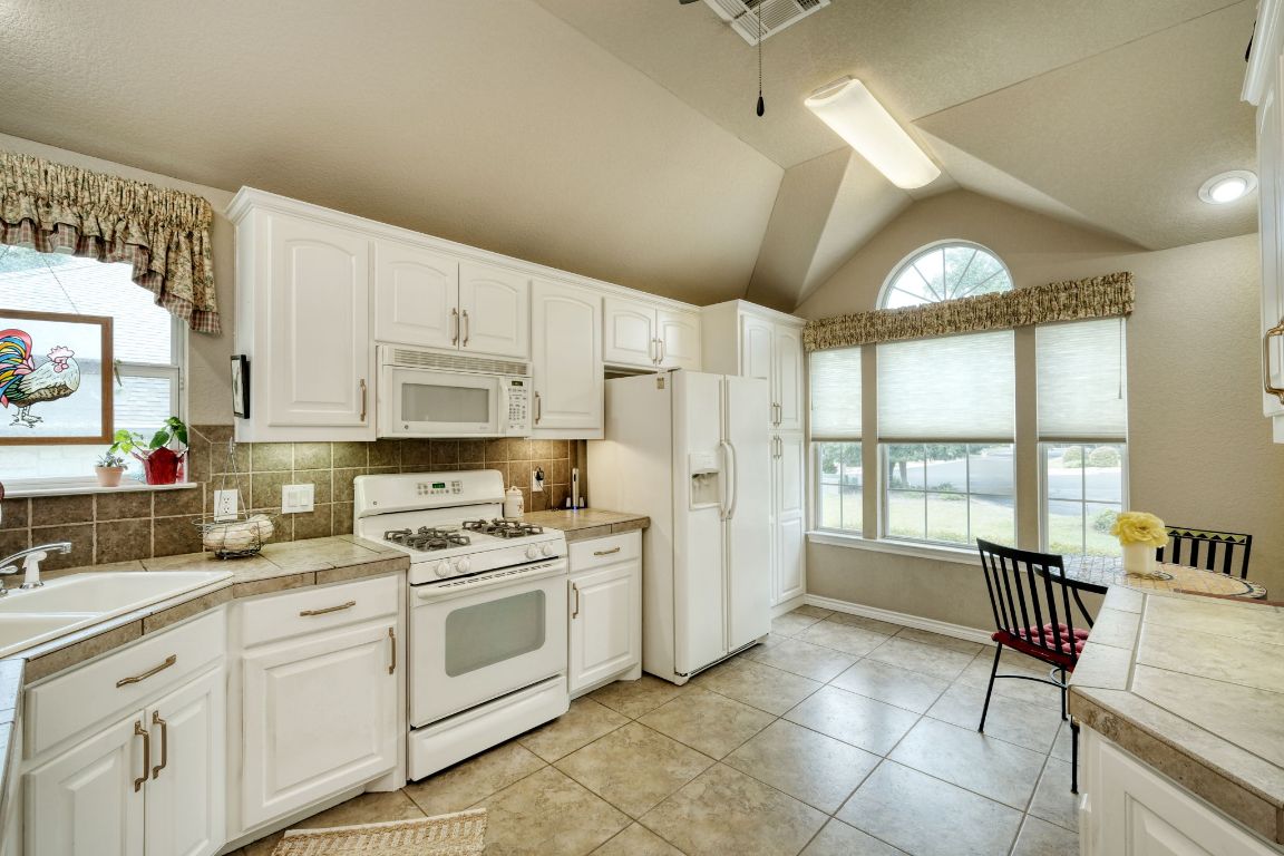 102 Texas Traditions Georgetown, TX 78628 - Photo 10 of 32 a kitchen with a white cabinets and white appliances