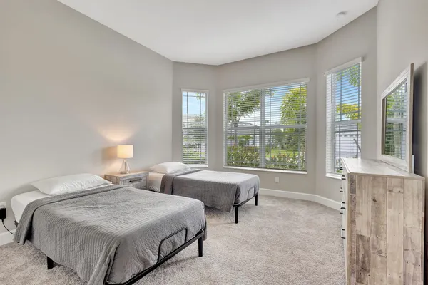 a spacious bedroom with two beds and a large window