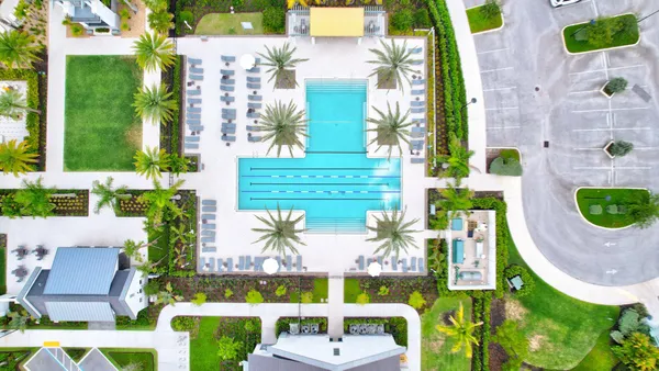 an aerial view of a residential apartment building with a yard and plants