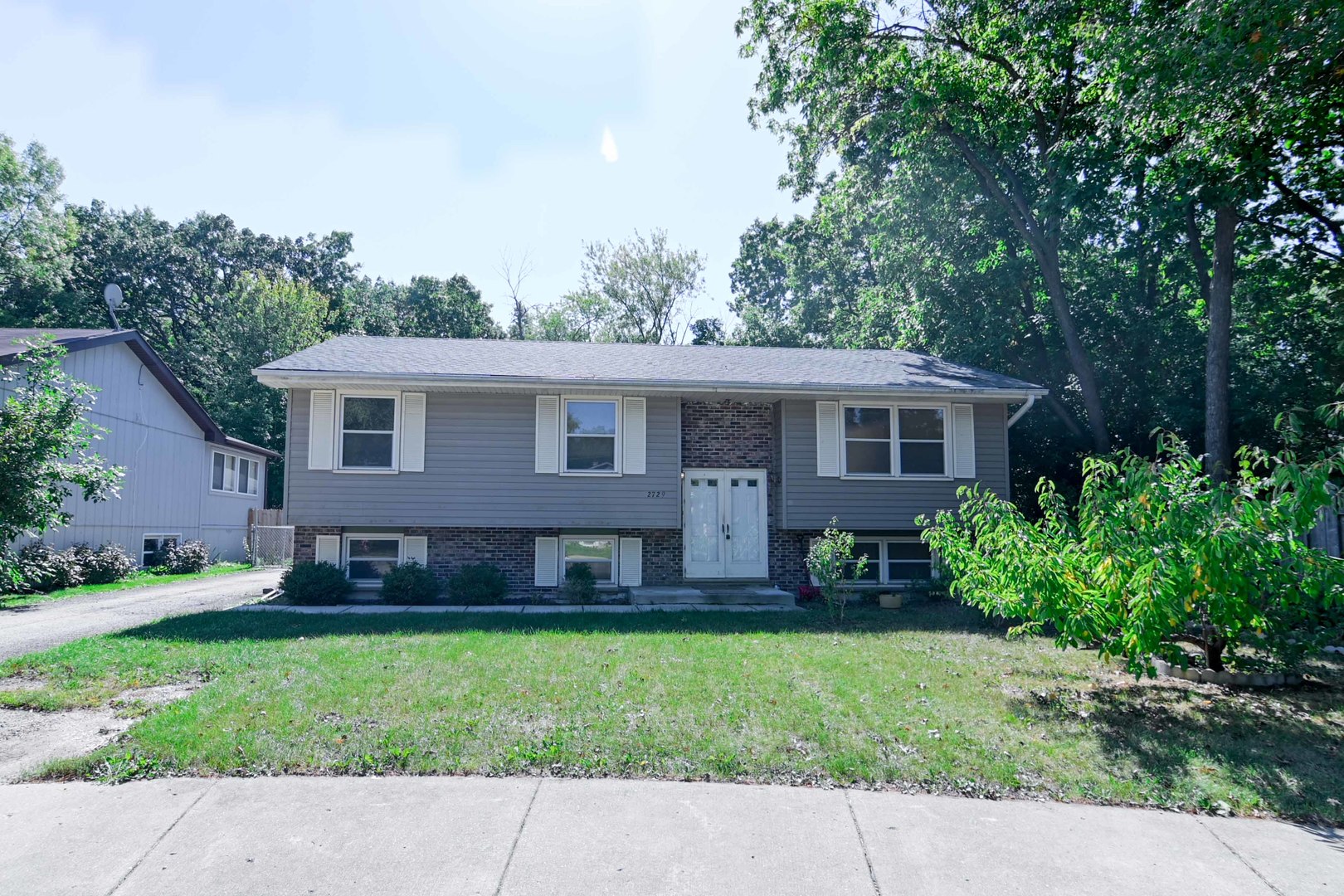 a front view of house with yard and green space