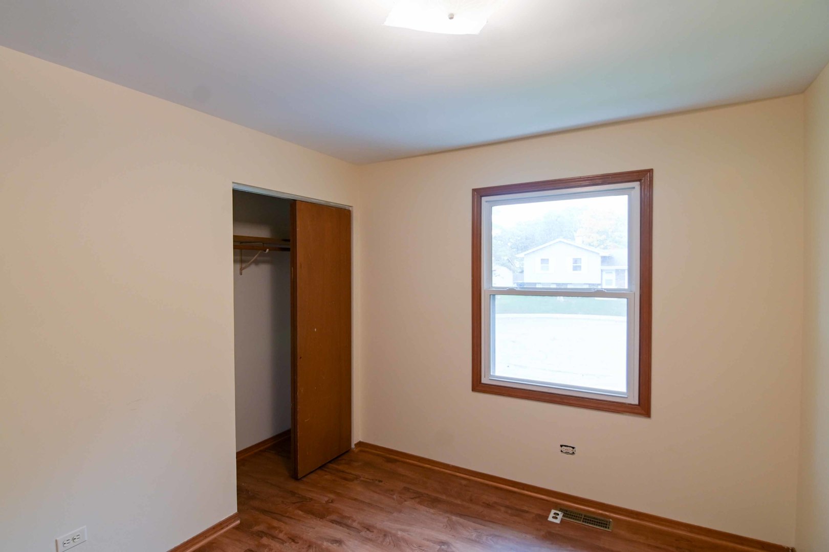 2729 Lowery Court Zion, IL 60099 - Photo 17 of 36 a view of an empty room with wooden floor and a window