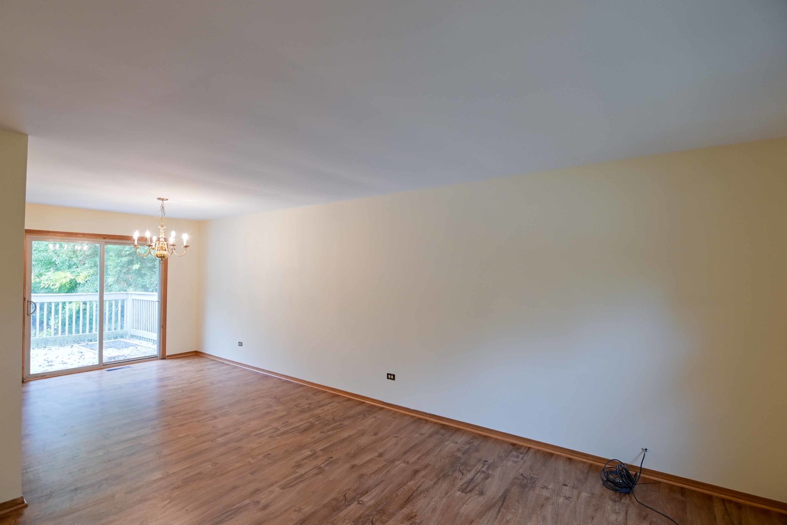 2729 Lowery Court Zion, IL 60099 - Photo 7 of 36 a view of an empty room with wooden floor and a window