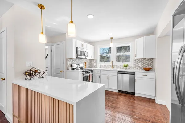 a kitchen with stainless steel appliances kitchen island a refrigerator sink and cabinets