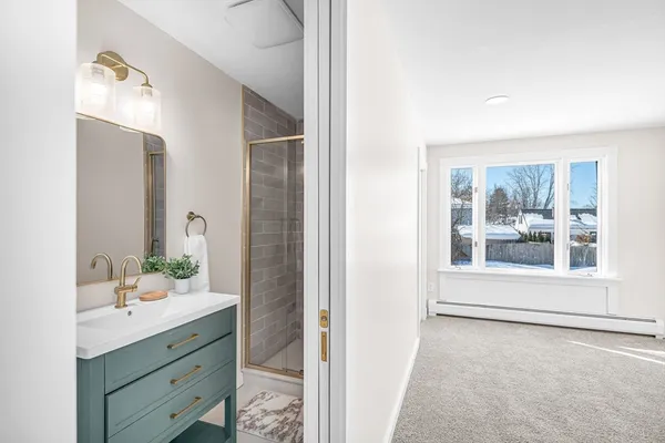 a bathroom with a sink mirror and a shower