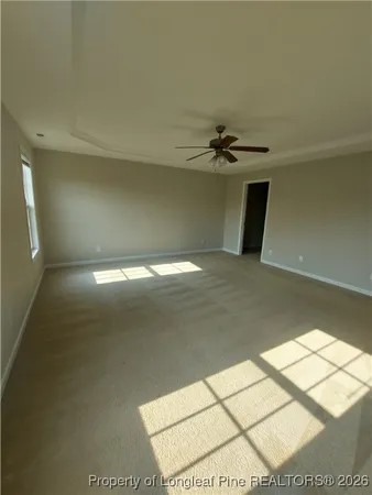 an empty room with windows and ceiling fan