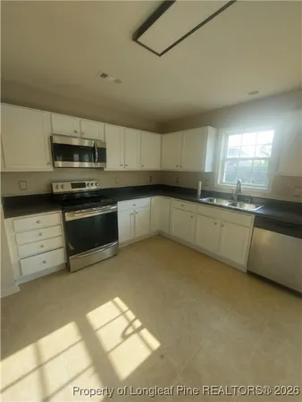 a kitchen with stainless steel appliances granite countertop a sink and stove top oven
