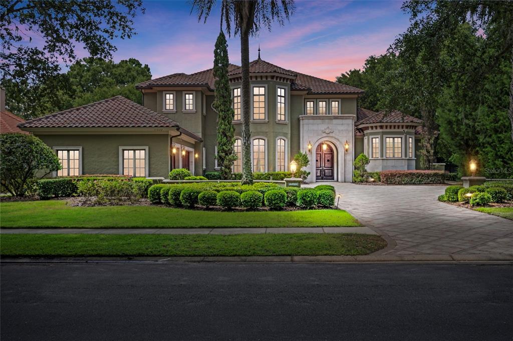 a front view of a house with a garden and plants
