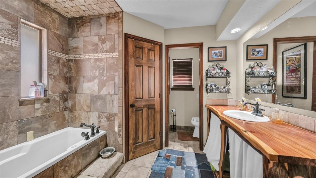 351 Don Propp Road Azle, TX 76020 - Photo 16 of 36 a bathroom with a tub sink and mirror
