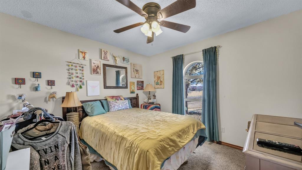 351 Don Propp Road Azle, TX 76020 - Photo 22 of 36 a bedroom with a bed and a chandelier