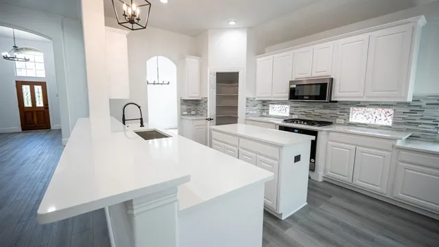 a kitchen with a sink a stove and cabinets