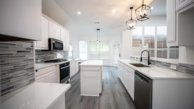 a kitchen with stainless steel appliances granite countertop a sink stove and refrigerator