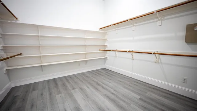 a view of walk in closet with empty racks