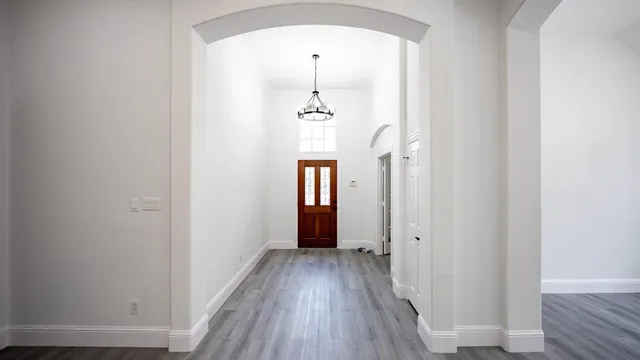 a view of a hallway with wooden floor and staircase