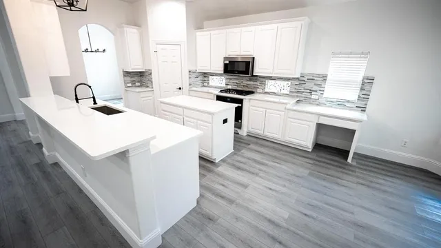 a kitchen with a sink stove top oven and microwave
