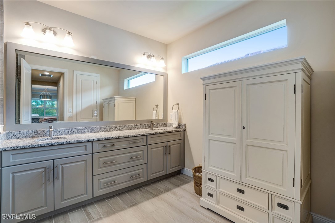 9292 Cayman Drive Naples, FL 34114 - Photo 16 of 50 a bathroom with a granite countertop sink and a mirror