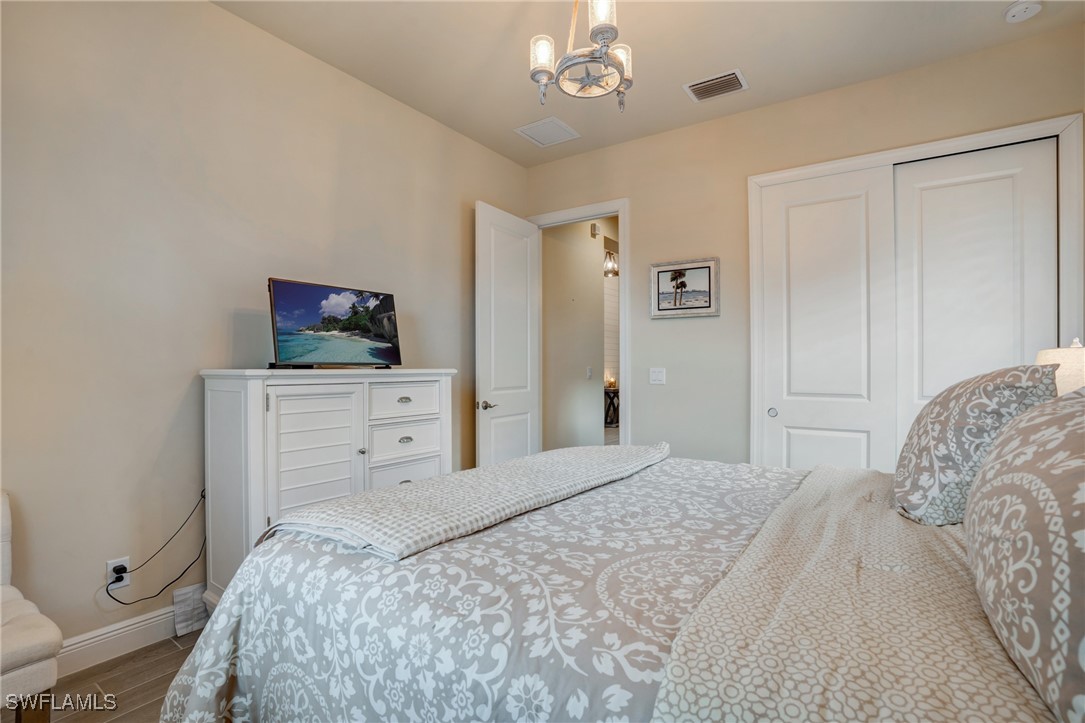 9292 Cayman Drive Naples, FL 34114 - Photo 19 of 50 a bedroom with a bed and a chandelier