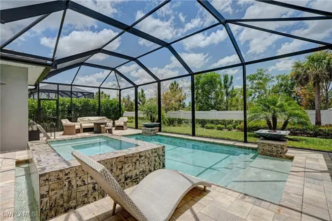 a kitchen with granite countertop a sink dishwasher a stove and white cabinets with wooden floor