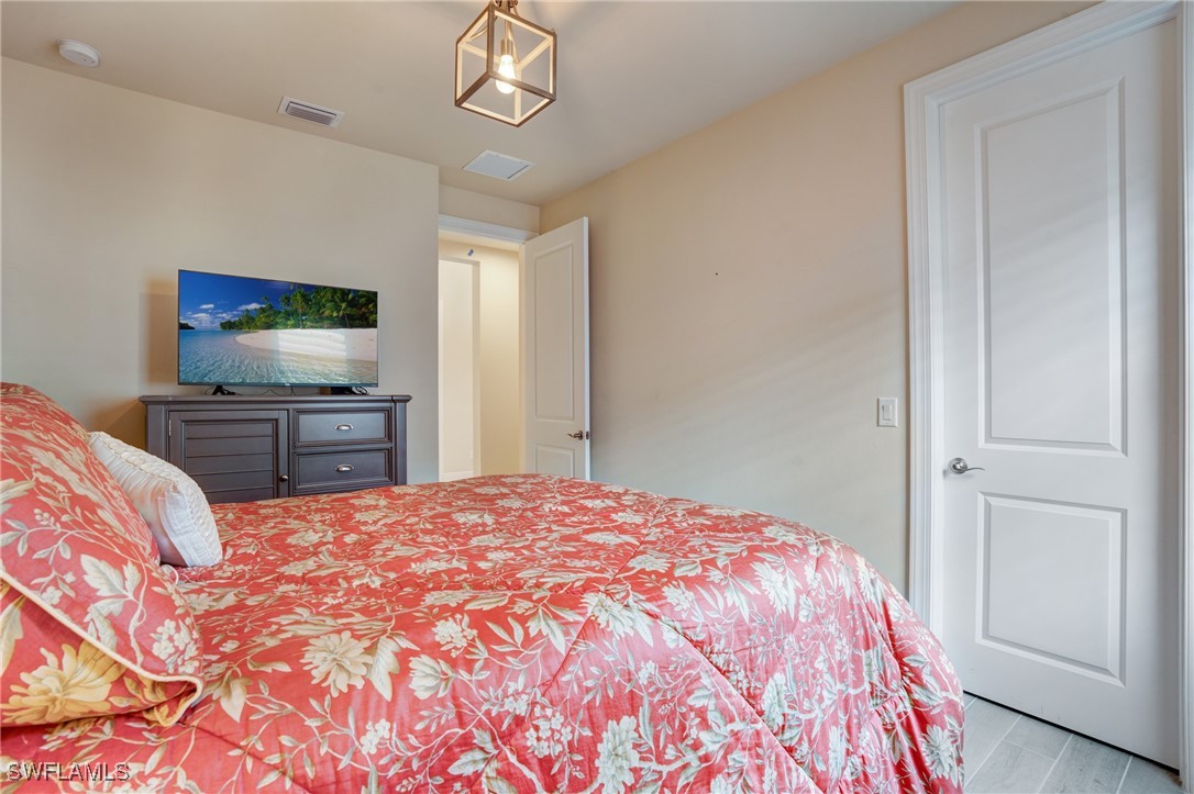 9292 Cayman Drive Naples, FL 34114 - Photo 22 of 50 a bedroom with a bed and a flat screen tv
