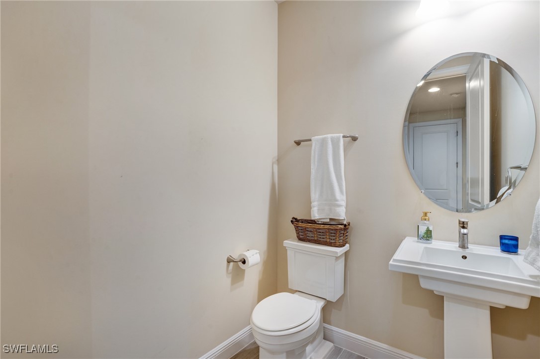9292 Cayman Drive Naples, FL 34114 - Photo 23 of 50 a bathroom with a toilet a sink and mirror