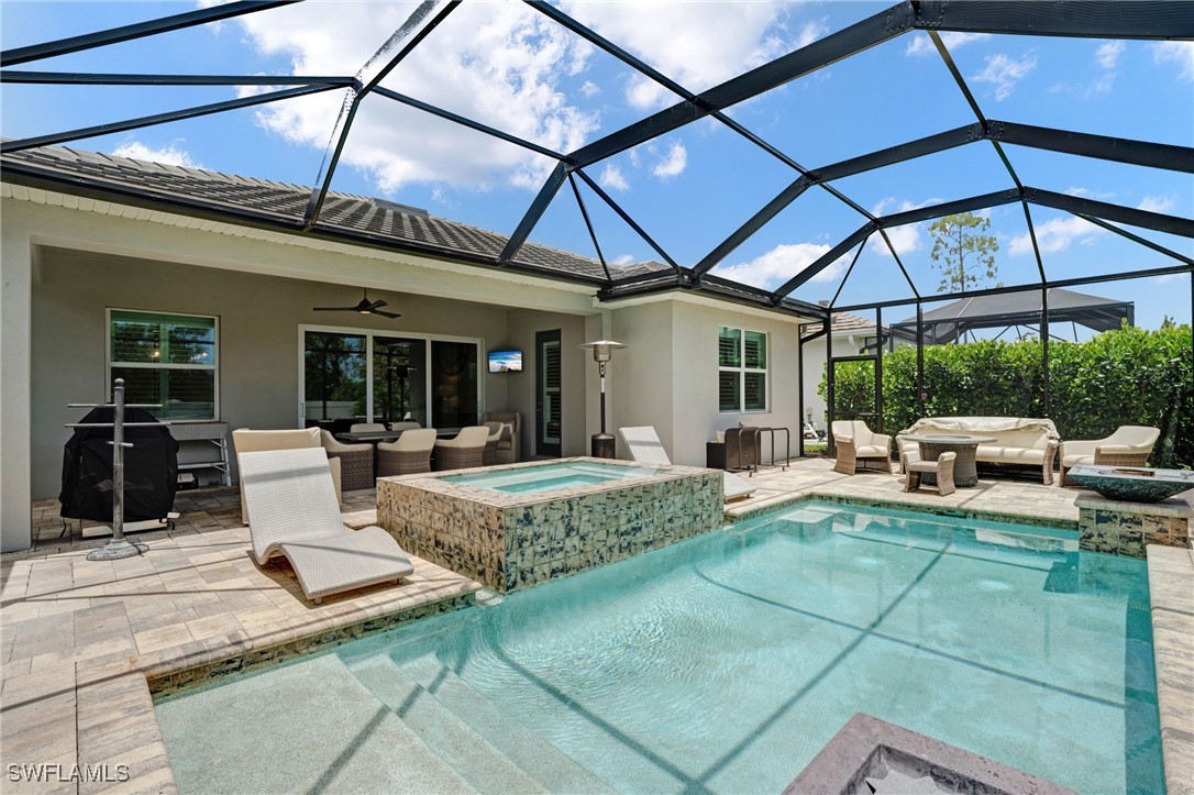 9292 Cayman Drive Naples, FL 34114 - Photo 33 of 50 a view of a patio with table and chairs under an umbrella
