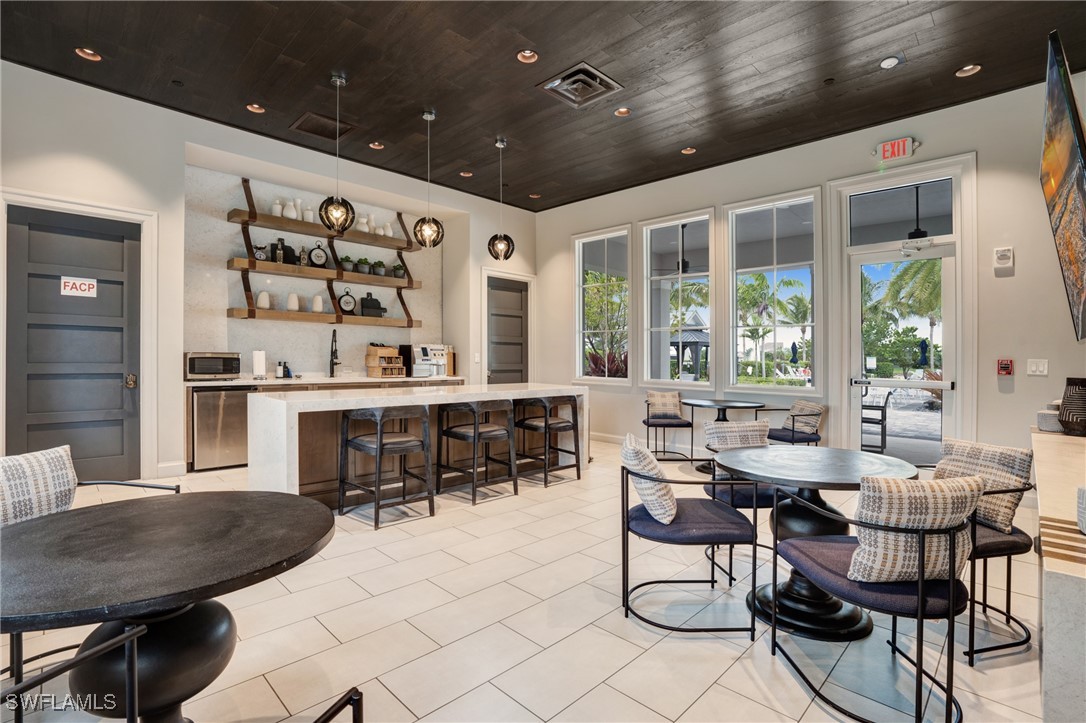 9292 Cayman Drive Naples, FL 34114 - Photo 42 of 50 a dining room with stainless steel appliances kitchen island granite countertop a table and chairs