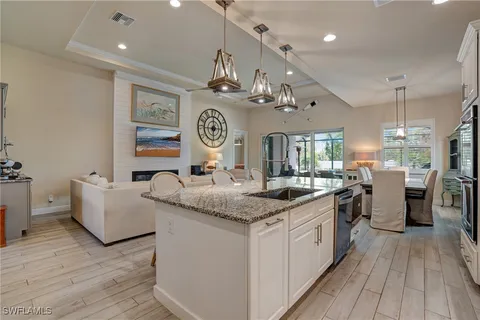 a living room with furniture a rug and kitchen view