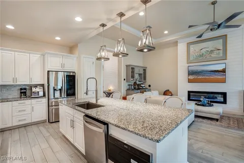 a living room with furniture kitchen view and a large window