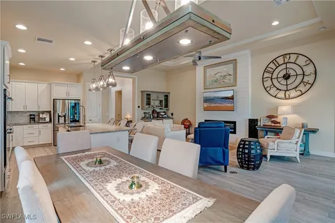 a living room with furniture kitchen view and a chandelier