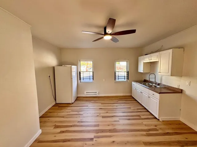 a large kitchen with cabinets wooden floor and stainless steel appliances