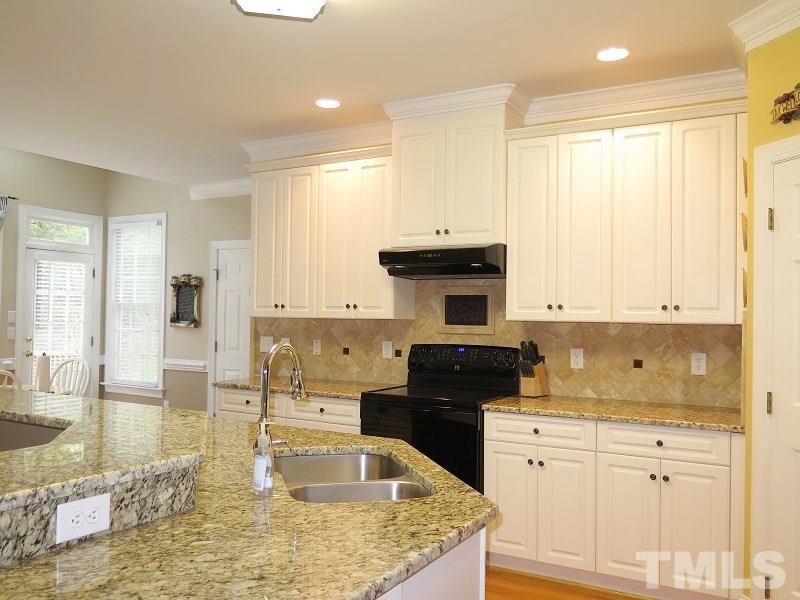 809 Nolstead Court Raleigh, NC 27614 - Photo 7 of 23 a kitchen with kitchen island granite countertop a sink a stove and cabinets