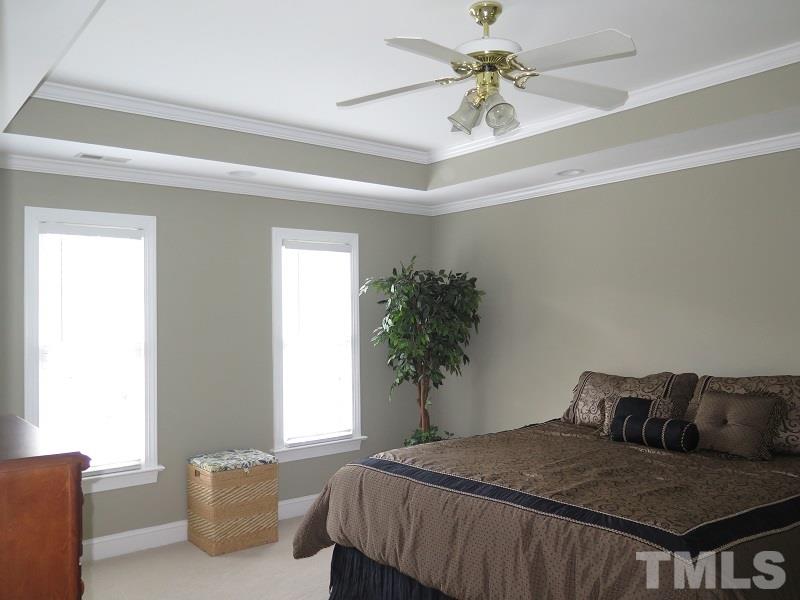 809 Nolstead Court Raleigh, NC 27614 - Photo 10 of 23 a bedroom with a bed and a chandelier