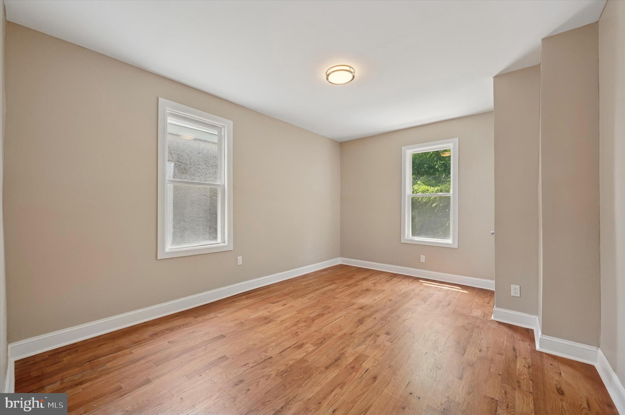 6212 Callowhill Street Philadelphia, PA 19151 - Photo 17 of 23 an empty room with wooden floor and windows