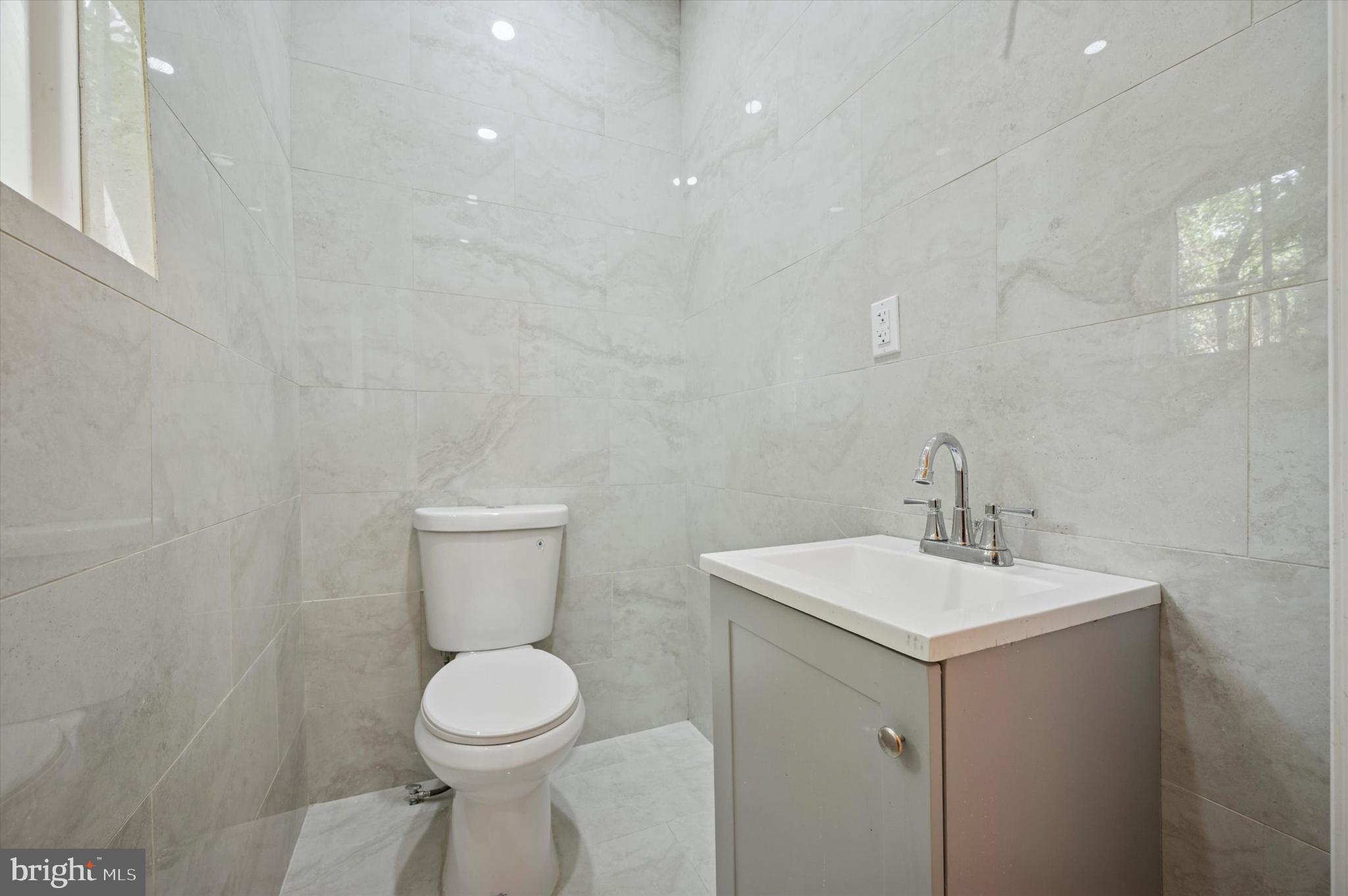 6212 Callowhill Street Philadelphia, PA 19151 - Photo 9 of 23 a bathroom with a toilet sink and mirror