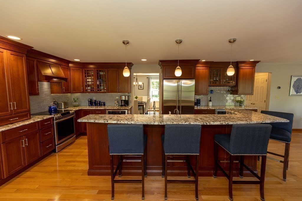8 Merrimack River Road Groveland, MA 01834 - Photo 12 of 39 a kitchen with stainless steel appliances granite countertop table chairs sink and cabinets