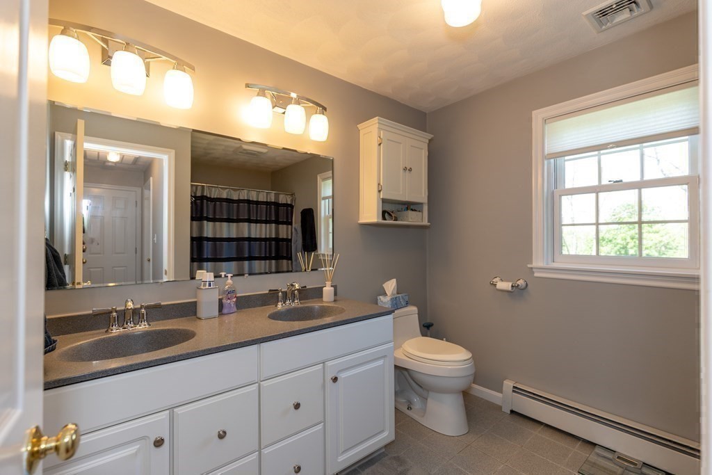 8 Merrimack River Road Groveland, MA 01834 - Photo 22 of 39 a bathroom with a toilet a double vanity sink a mirror and a window