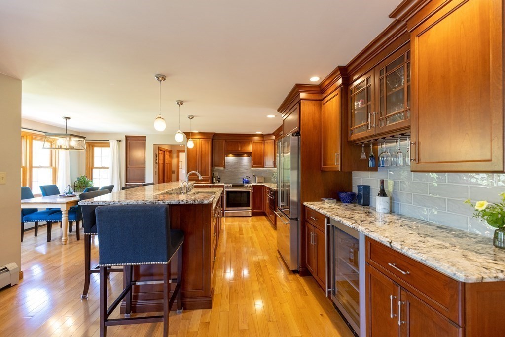 8 Merrimack River Road Groveland, MA 01834 - Photo 7 of 39 a kitchen with stainless steel appliances granite countertop a stove a sink dishwasher and a dining table with wooden floor