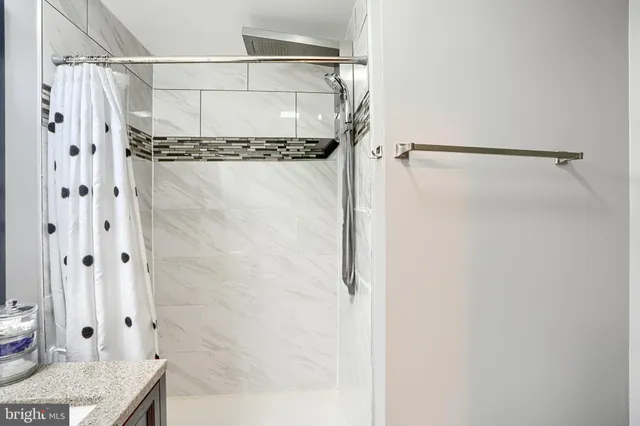 a bathroom with a granite countertop shower and a sink