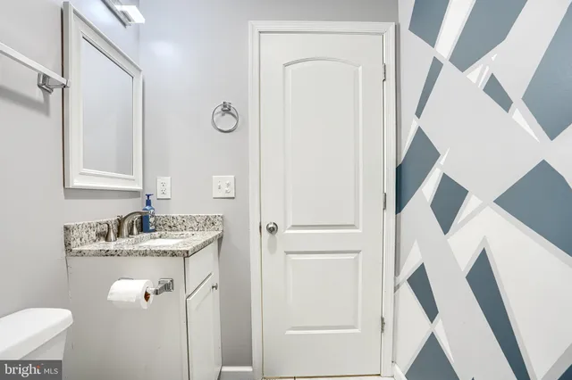 a bathroom with a sink a toilet and a mirror
